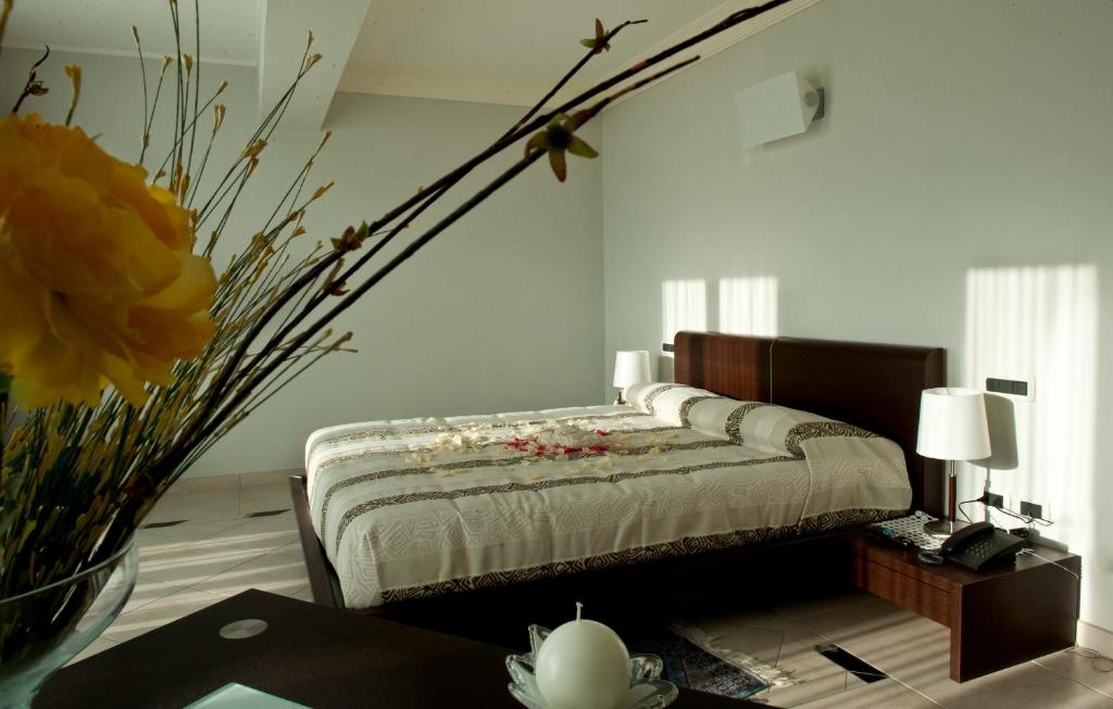 - une chambre avec un lit et un vase de fleurs dans l'établissement Park Hotel Tyrrenian, à Amantea