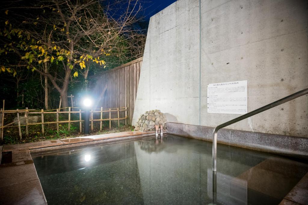 une piscine devant un immeuble la nuit dans l'établissement Shimantonoyado, à Shimanto