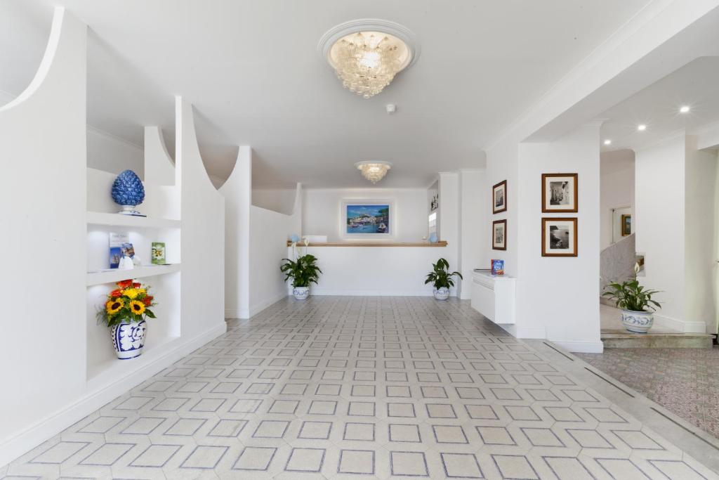 un couloir vide avec des murs blancs et un lustre dans l'établissement Hotel Piccolo Paradiso, à Massa Lubrense 29 autres photos