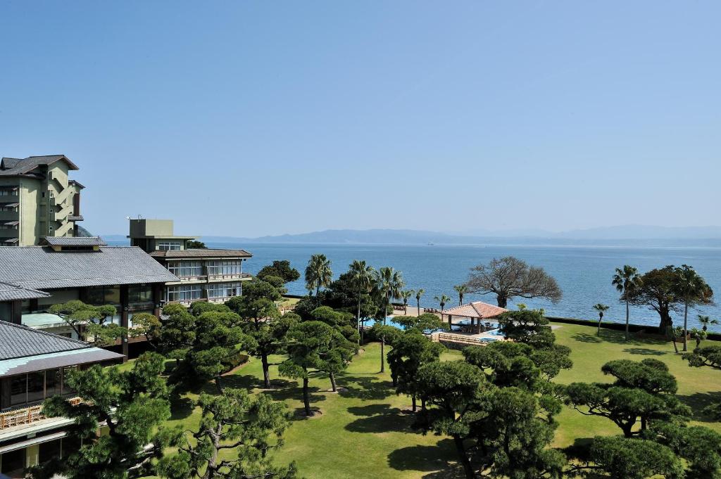 une vue aérienne d'un complexe hôtelier avec des arbres et l'océan dans l'établissement Kagoshima Sunamushionsen Ibusuki Hakusuikan, à Ibusuki