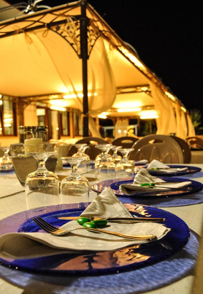 une table avec des assiettes, des fourchettes et des serviettes dans l'établissement Lido Impero, à Palagiano