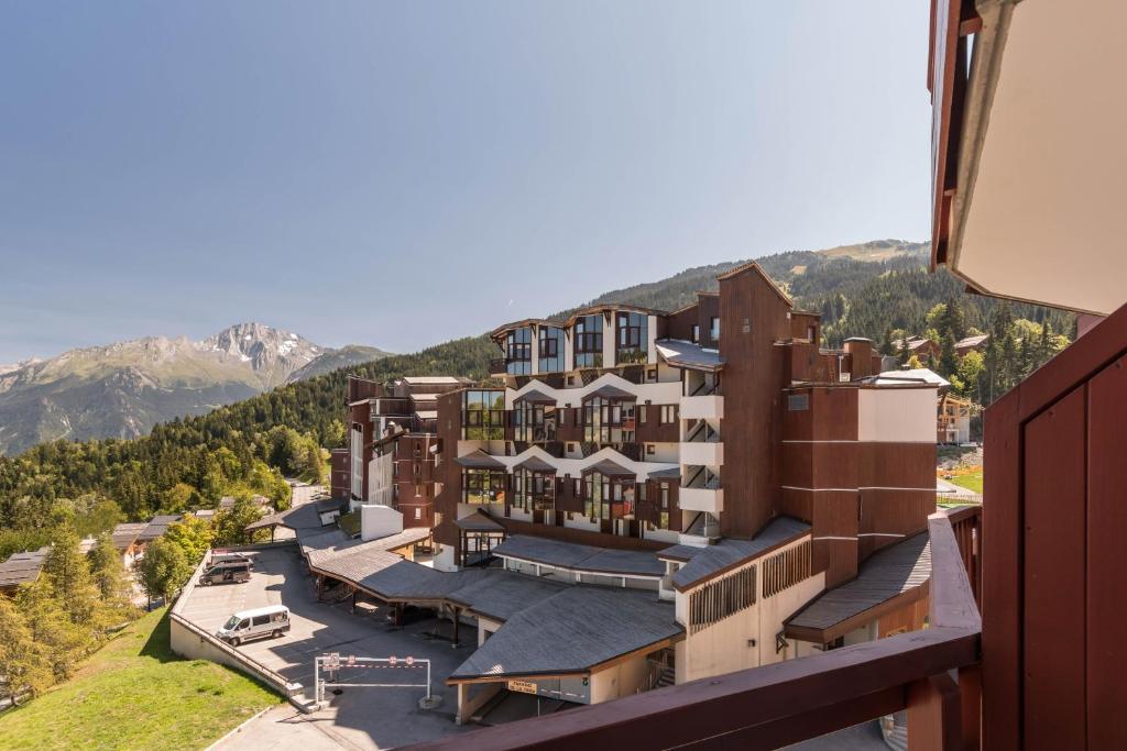 une vue aérienne sur un bâtiment avec des montagnes en arrière-plan dans l'établissement Résidence Pierre & Vacances Le Britania, à La Tania
