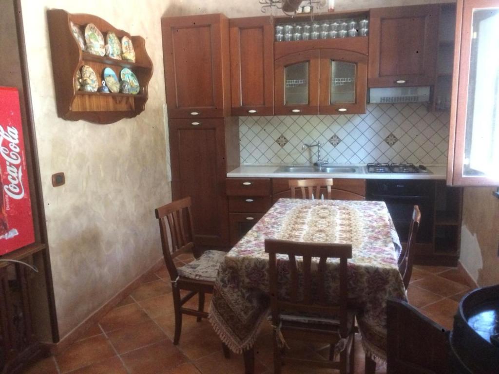une cuisine avec une table et des chaises dans une cuisine dans l'établissement Villa delle Rose, à Boscotrecase