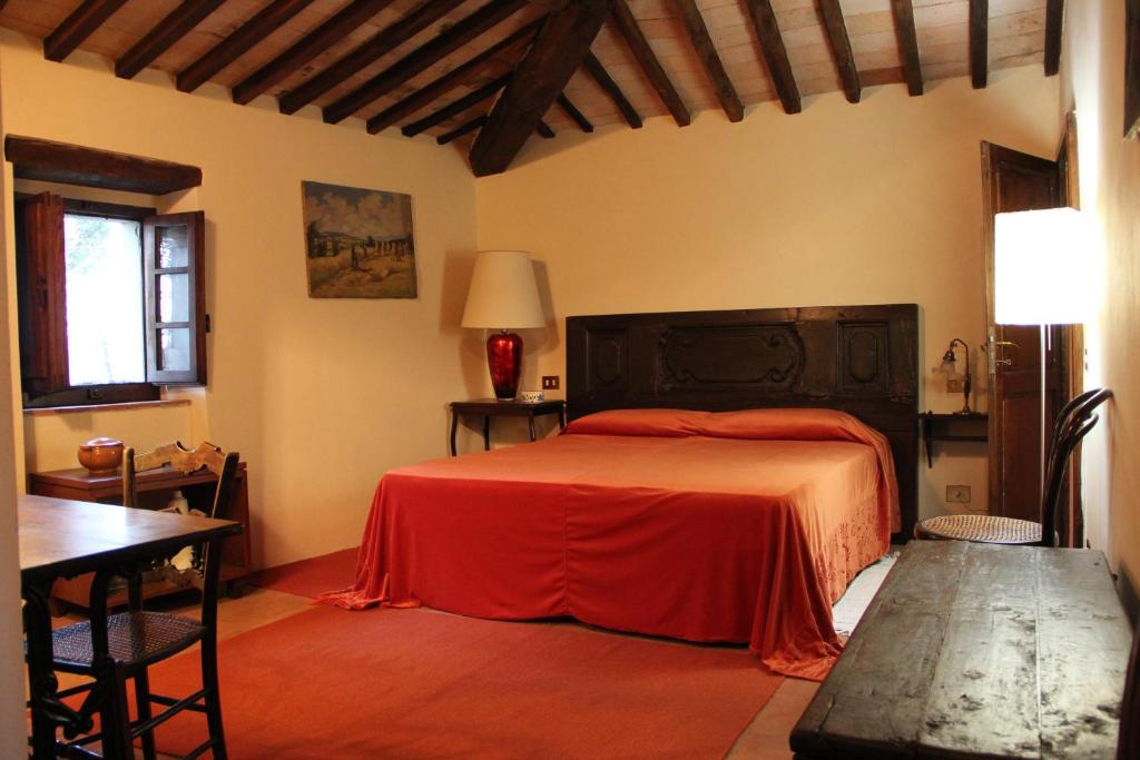 une chambre avec un lit avec une couette rouge dans l'établissement Poggio dell'Esca, à Sansepolcro