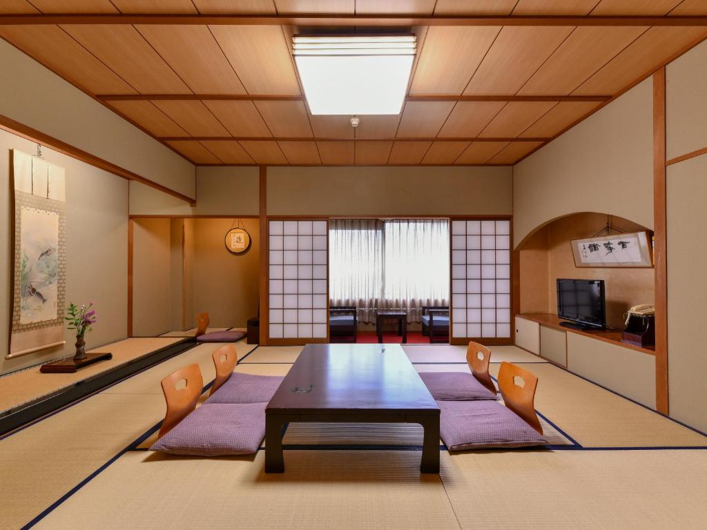 une salle de conférence avec une table et des chaises dans l'établissement Awara Onsen Minoya Taiheikaku, à Awara