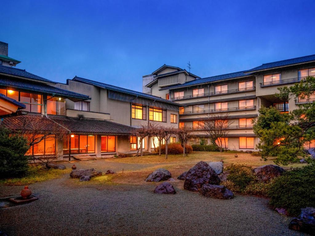 un grand bâtiment avec des rochers devant lui dans l'établissement Awara Onsen Minoya Taiheikaku, à Awara