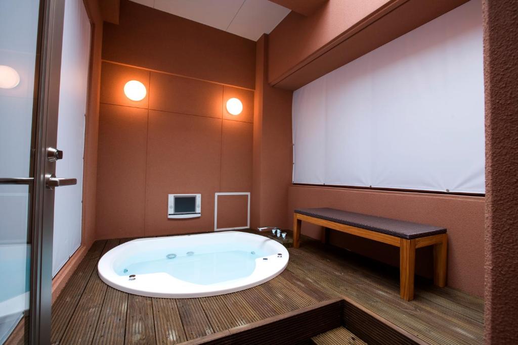 une grande baignoire dans une pièce avec une grande fenêtre dans l'établissement Hotel Bintang Pari Resort (Adult Only), à Kobe