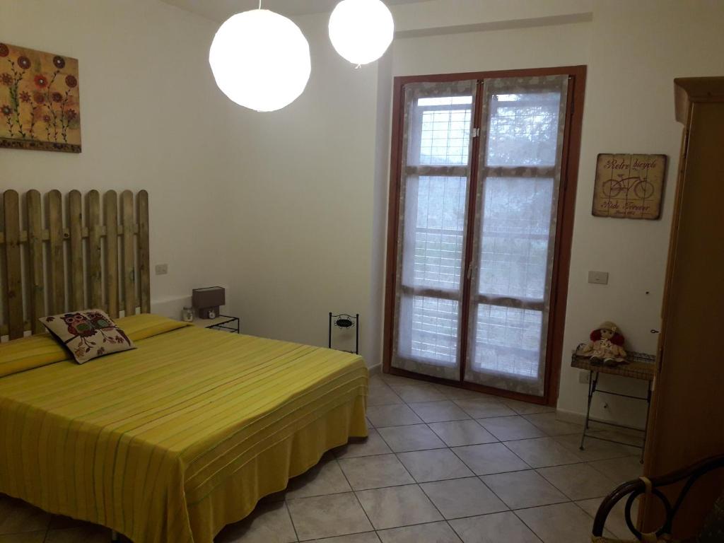 une chambre avec un lit et une grande fenêtre dans l'établissement La casa di Eva, à Castel Viscardo