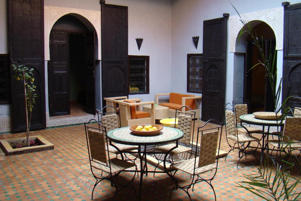 une chambre avec deux tables et chaises et une table asteryasteryasteryasteryasteryastery dans l'établissement Riad Menthe Et Citron, à Meknès