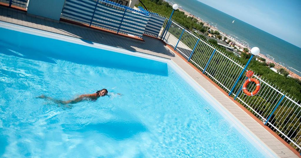 un homme se baignant dans une piscine au bord de l'océan dans l'établissement Hotel Atlantic Riviera Mare, à Misano Adriatico