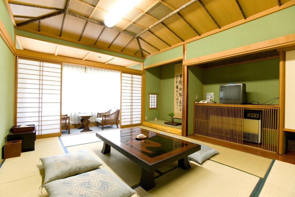 un salon avec une table et une télévision dans l'établissement Kikori, à Fuefuki 35 autres photos