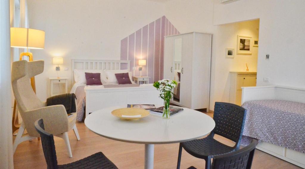 une pièce avec une table et des chaises et une chambre dans l'établissement Petit Hotel, à Lido di Camaiore