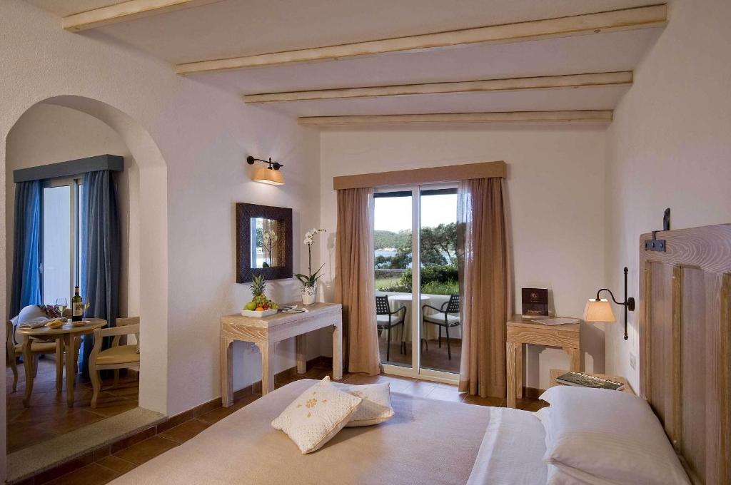 un salon avec un canapé et une salle à manger dans l'établissement COLONNA GRAND HOTEL CAPO TESTA, a Colonna Luxury Beach Hotel, Santa Teresa Sardegna, à Santa Teresa Gallura