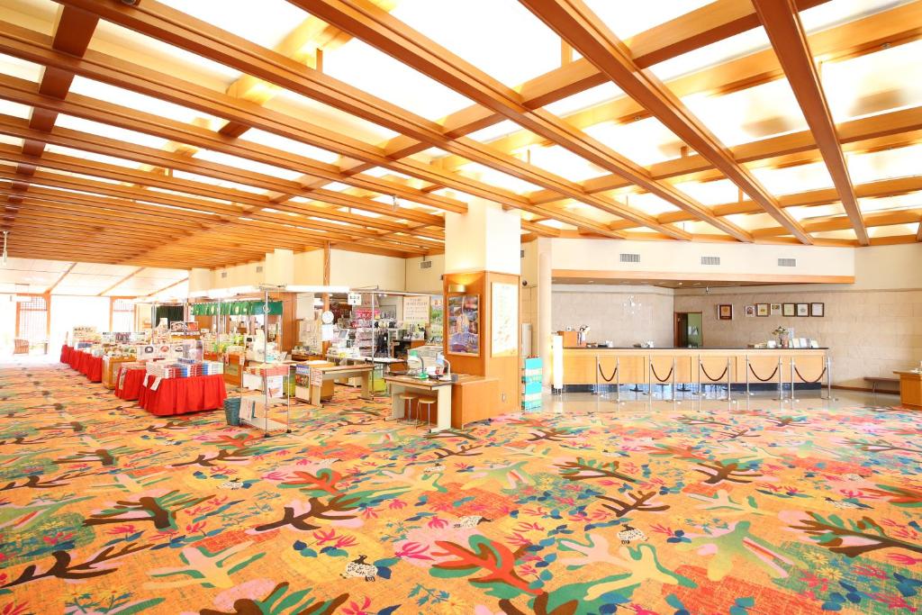 un grand hall avec une cafétéria dotée de tables et de chaises dans l'établissement Tateyama Prince Hotel, à Omachi