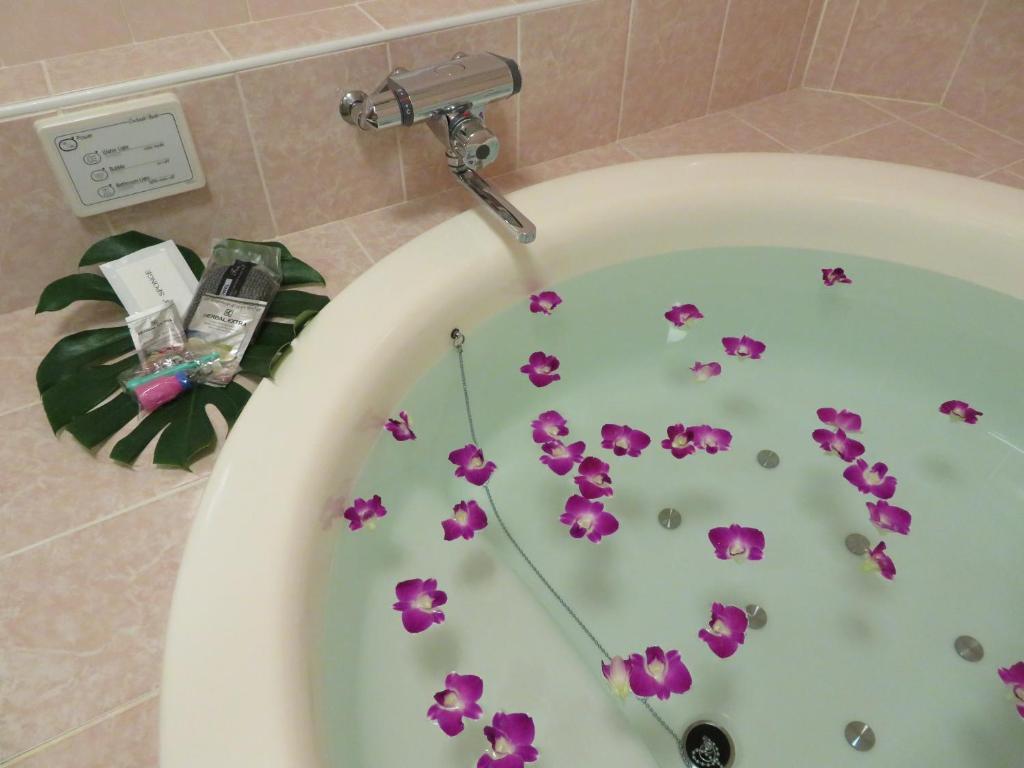 d'une baignoire avec des fleurs violettes. dans l'établissement Hotel AQUA Blue Yokosuka (Adult Only), à Yokosuka 43 autres photos