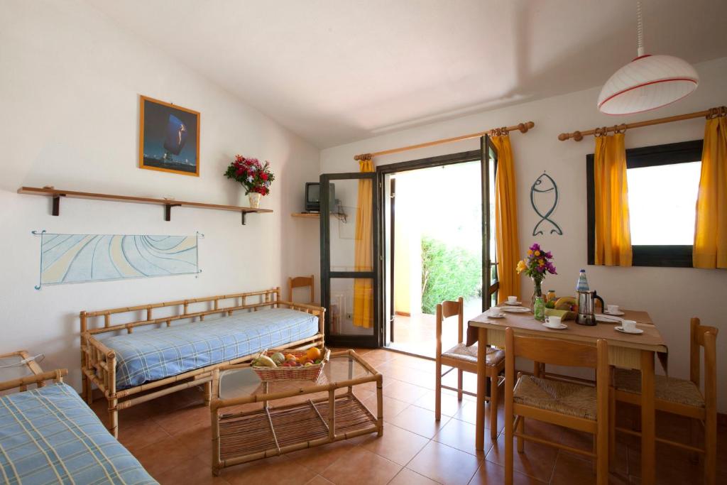 une chambre avec un lit et une table et une salle à manger dans l'établissement Residence Baia Salinedda, à San Teodoro