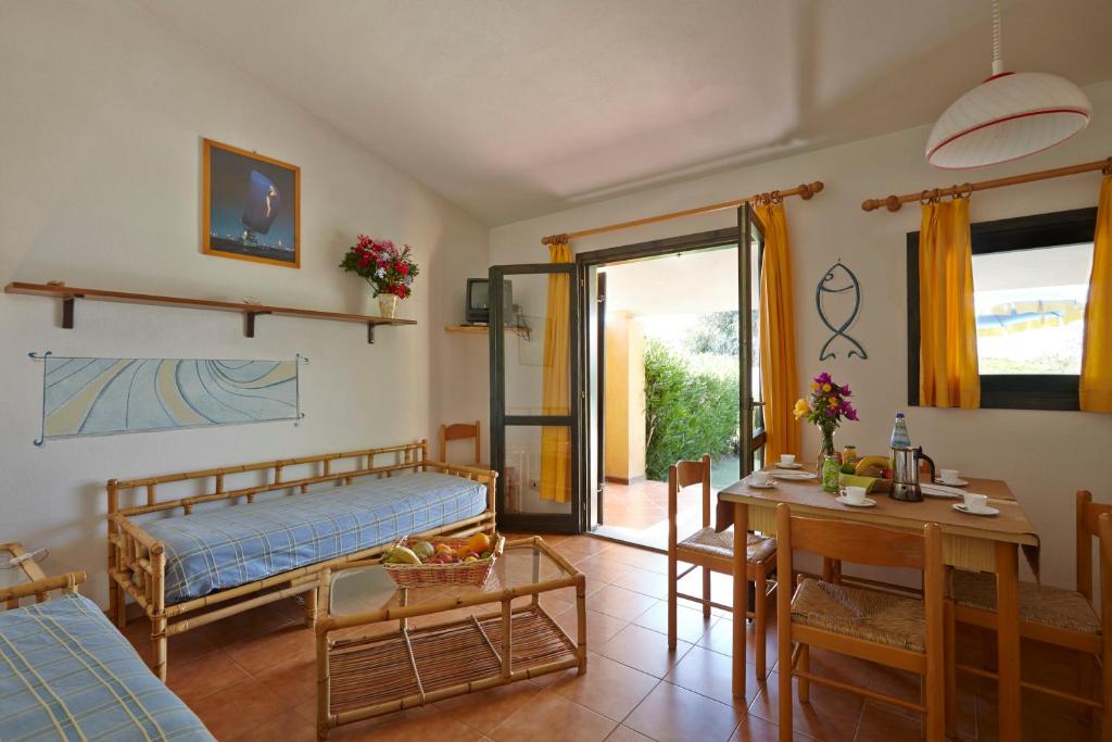 une chambre avec un lit et une table et une salle à manger dans l'établissement Residence Baia Salinedda, à San Teodoro