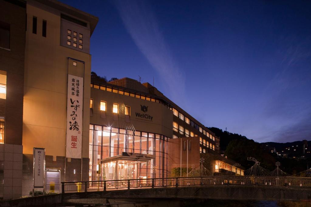 un bâtiment éclairé dans une ville la nuit dans l'établissement New Welcity Yugawara, à Atami