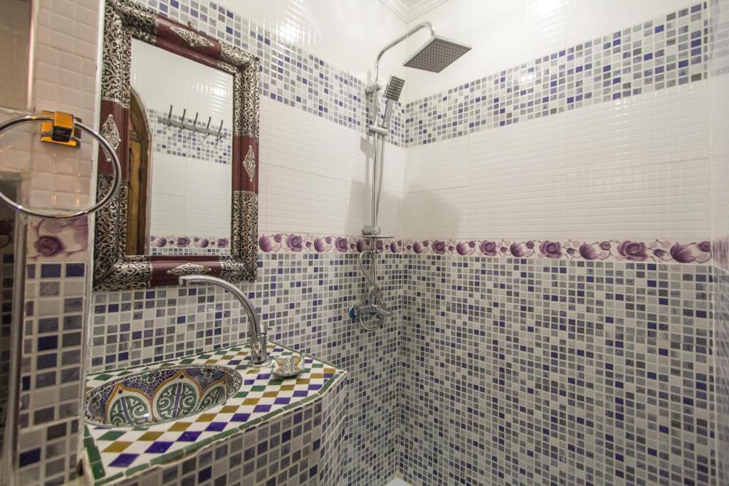 une salle de bain avec un lavabo et un miroir dans l'établissement Dar Meknes Tresor, à Meknès