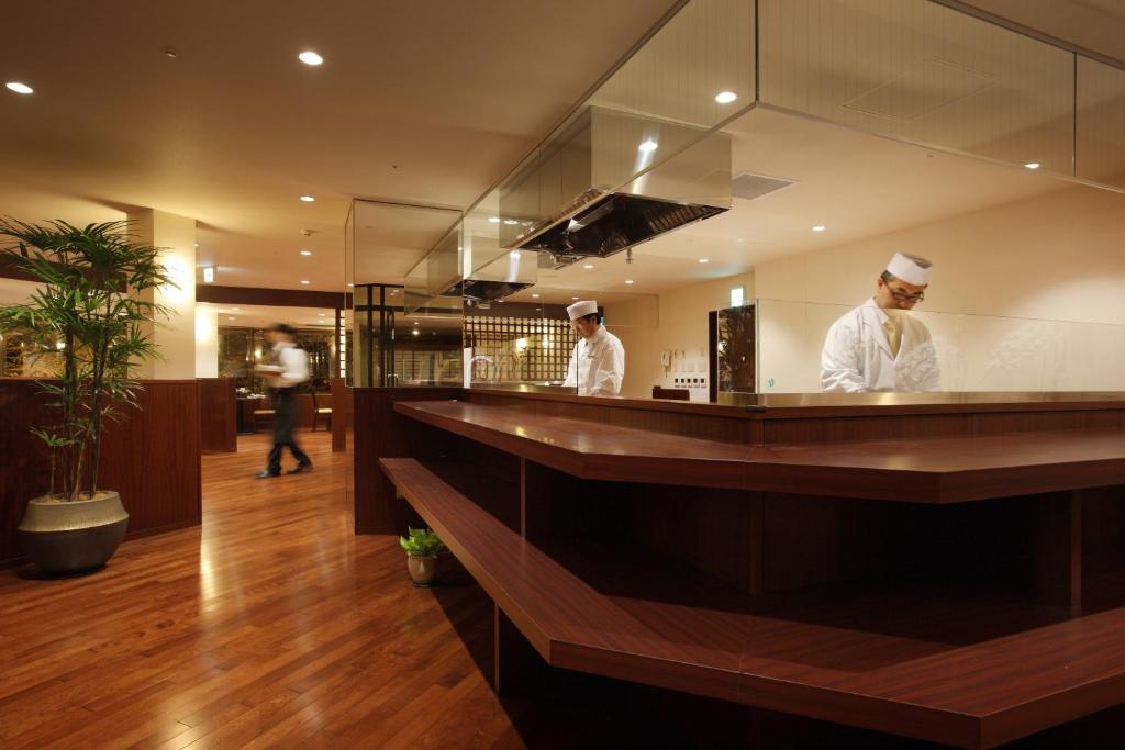 deux chefs debout derrière un comptoir dans une cuisine dans l'établissement 仙台秋保温泉 篝火の湯 緑水亭, à Sendai 66 autres photos