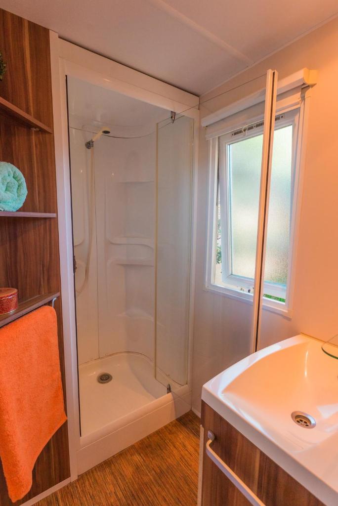 une salle de bain avec douche et lavabo dans l'établissement Camping Cap Sud, à Alénya