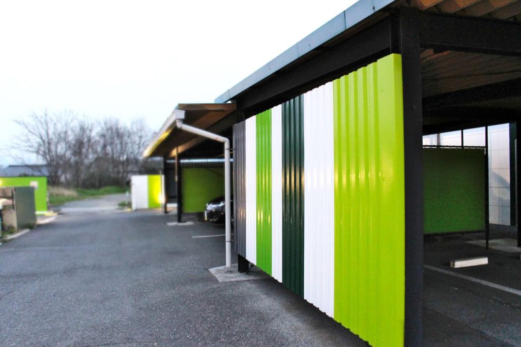 un bâtiment vert et blanc avec un parking dans l'établissement Pal Annex Nakatsu (Love Hotel), à Nakatsu