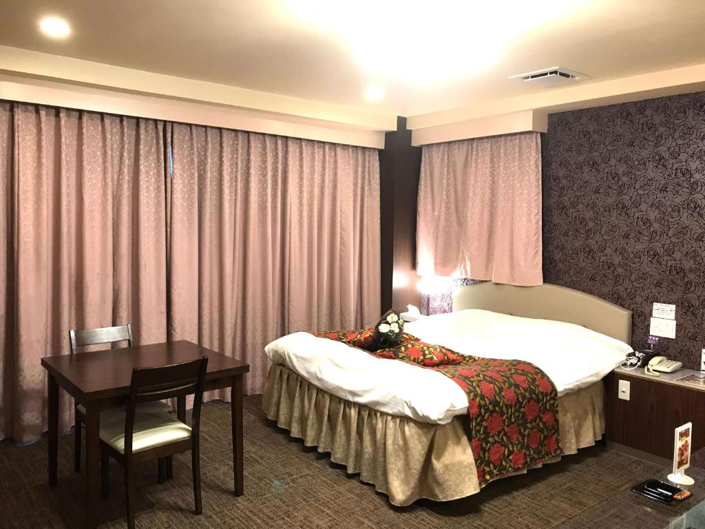 une chambre d'hôtel avec deux lits et une table dans l'établissement Pal Annex Nakatsu (Love Hotel), à Nakatsu