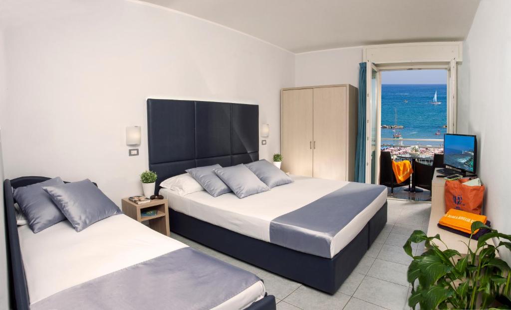 une chambre avec deux lits et une vue sur l'océan dans l'établissement Baby Family Hotel Alda Amelia, à Cattolica