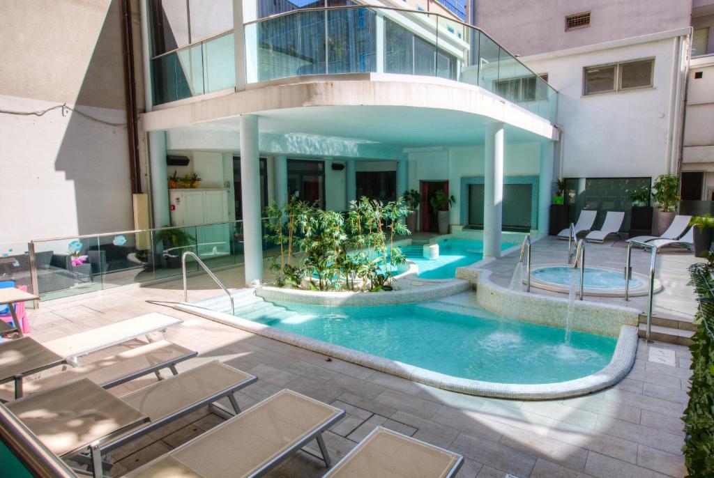 une piscine au milieu d'un immeuble dans l'établissement Baby Family Hotel Alda Amelia, à Cattolica