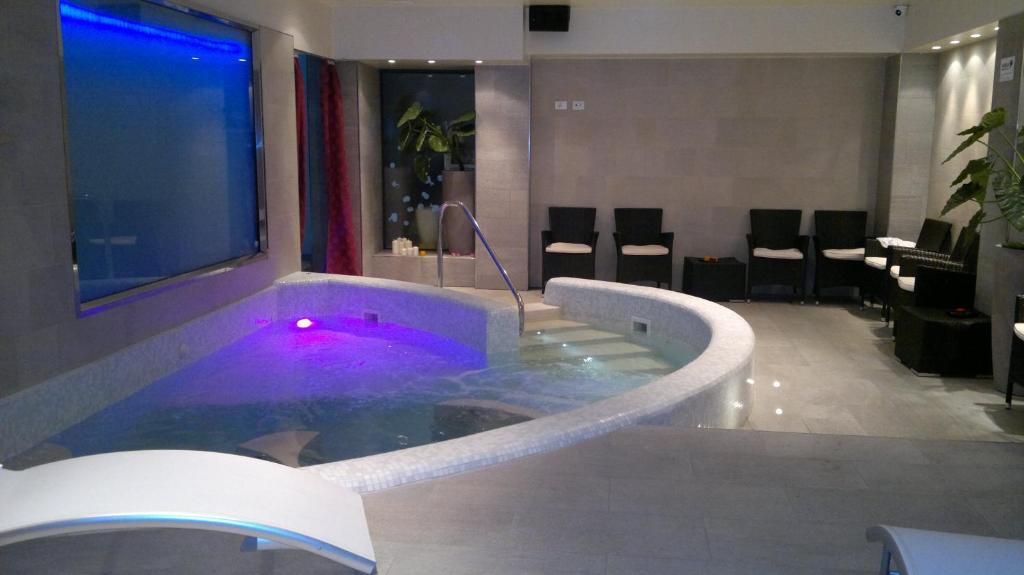 une baignoire jacuzzi dans le hall de l'hôtel avec des chaises dans l'établissement Baby Family Hotel Alda Amelia, à Cattolica