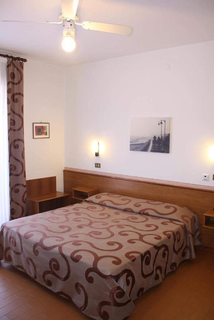 une chambre avec un lit dans une pièce dans l'établissement Hotel Helga, à Caorle
