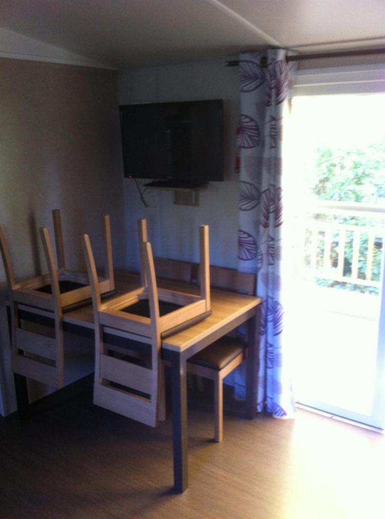 une salle à manger avec une table, des chaises et une télévision dans l'établissement GRAND MOBILEHOME PROCHE COMMODITE FO10, à Fréjus