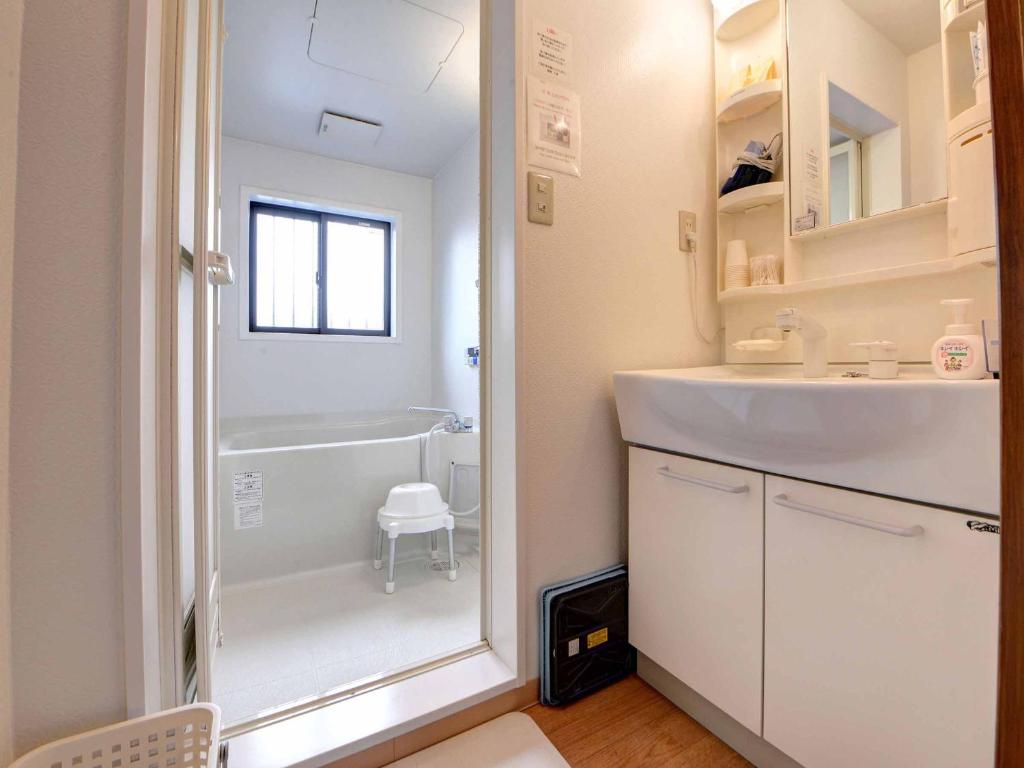 une salle de bain avec une baignoire, un lavabo et une douche dans l'établissement Ryokan Niko, à Koganei 37 autres photos