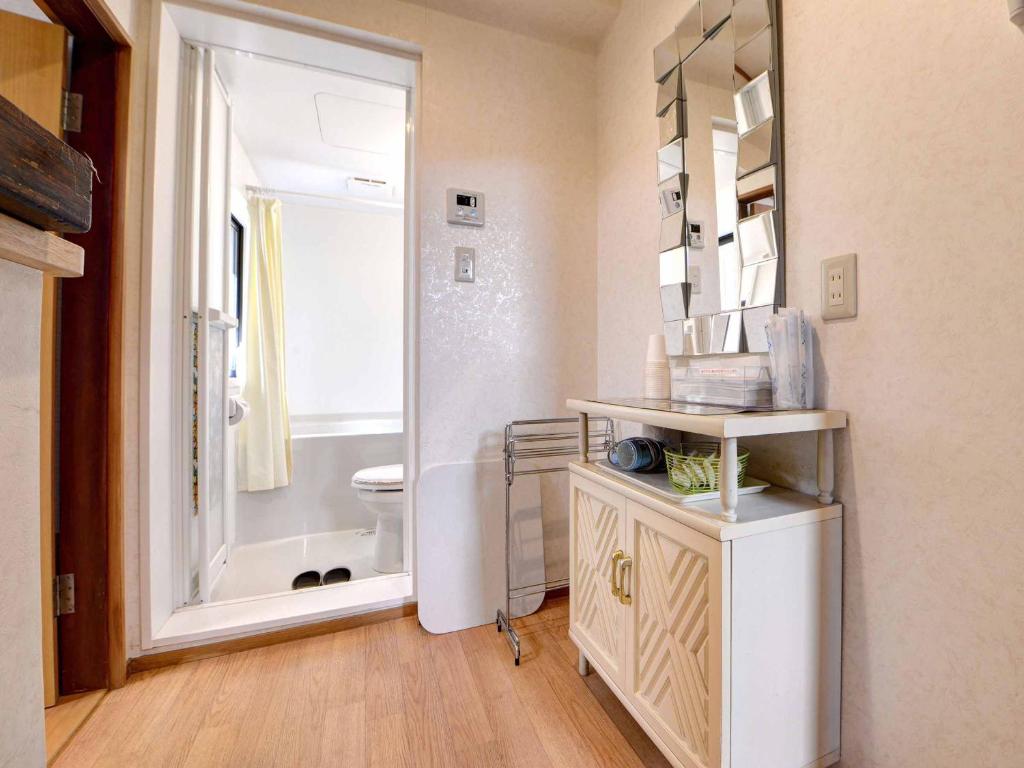 une salle de bain avec toilettes, lavabo et miroir dans l'établissement Ryokan Niko, à Koganei
