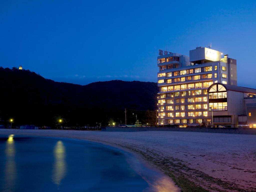 - un grand bâtiment sur la plage la nuit dans l'établissement Kaigetsukan, à Sumoto