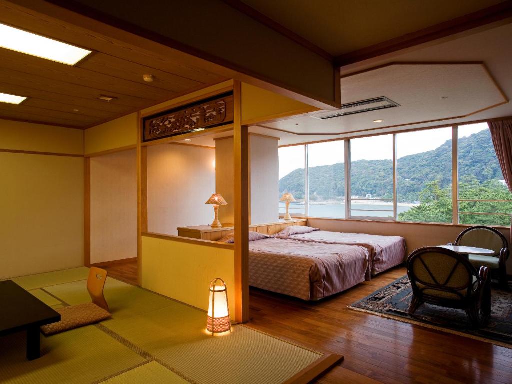 une chambre avec un lit et une grande fenêtre dans l'établissement Kaigetsukan, à Sumoto