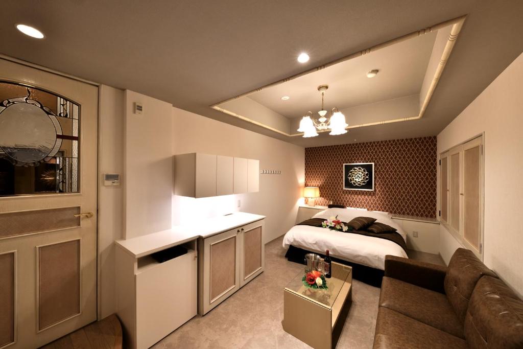une chambre avec un lit et un canapé dans une pièce dans l'établissement HOTEL MYTH-Y ホテル マイス ワイ adult only, à Kotohira