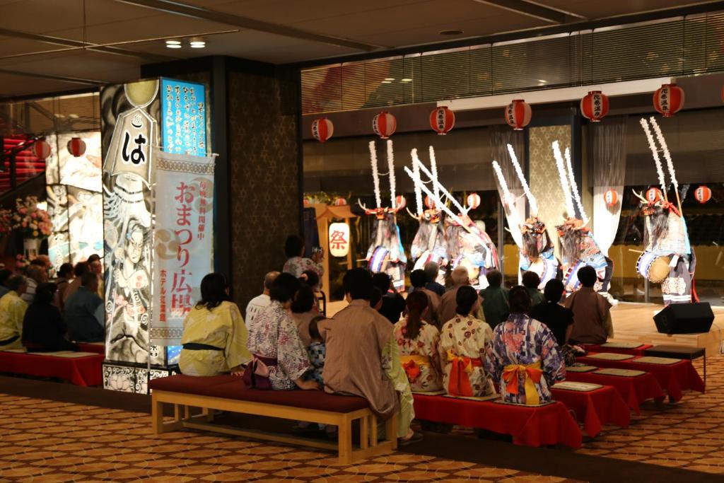 Un groupe de personnes assises sur des bancs qui assistent à un spectacle dans l'établissement Hotel Senshukaku, à Hanamaki 23 autres photos