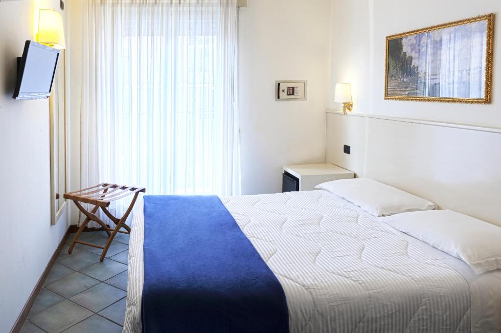 une chambre avec un lit, une chaise et une fenêtre dans l'établissement International Hotel & Suite - In prima fila sul lungomare, à San Benedetto del Tronto