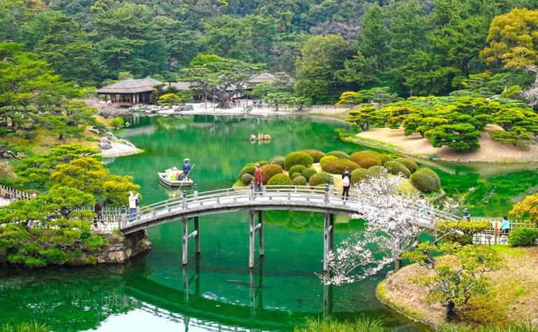 un pont sur une rivière avec des gens dessus dans l'établissement HOTEL MYTH-J -ホテル マイス ジェイ- adult only, à Sakaide