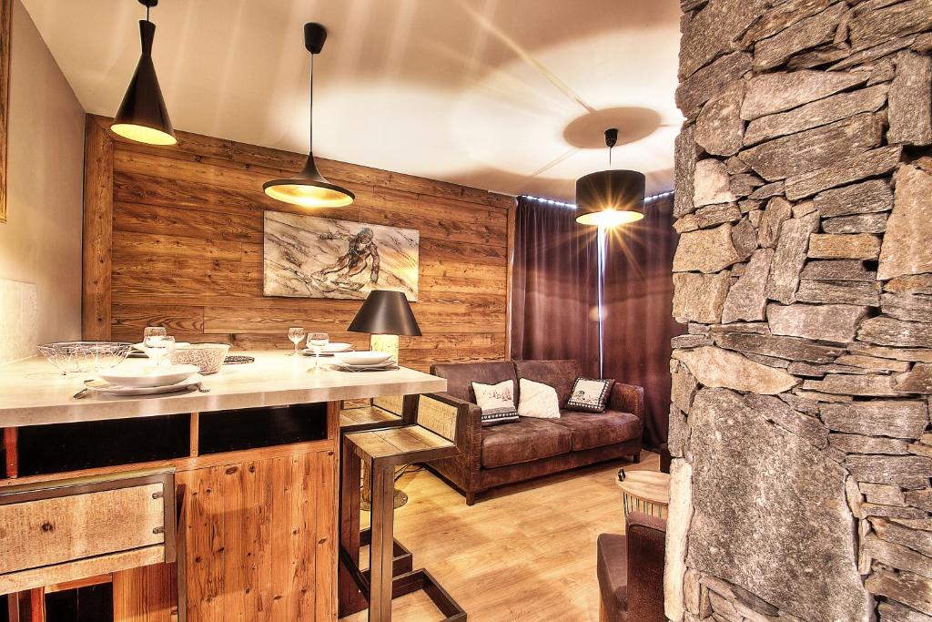 - une cuisine avec des murs en bois et un mur en pierre dans l'établissement Appartements résidence Roches Rouges, à Tignes