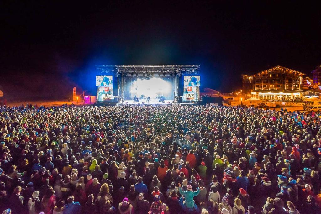 Une foule nombreuse de gens à un concert la nuit dans l'établissement Appartements résidence Roches Rouges, à Tignes 37 autres photos