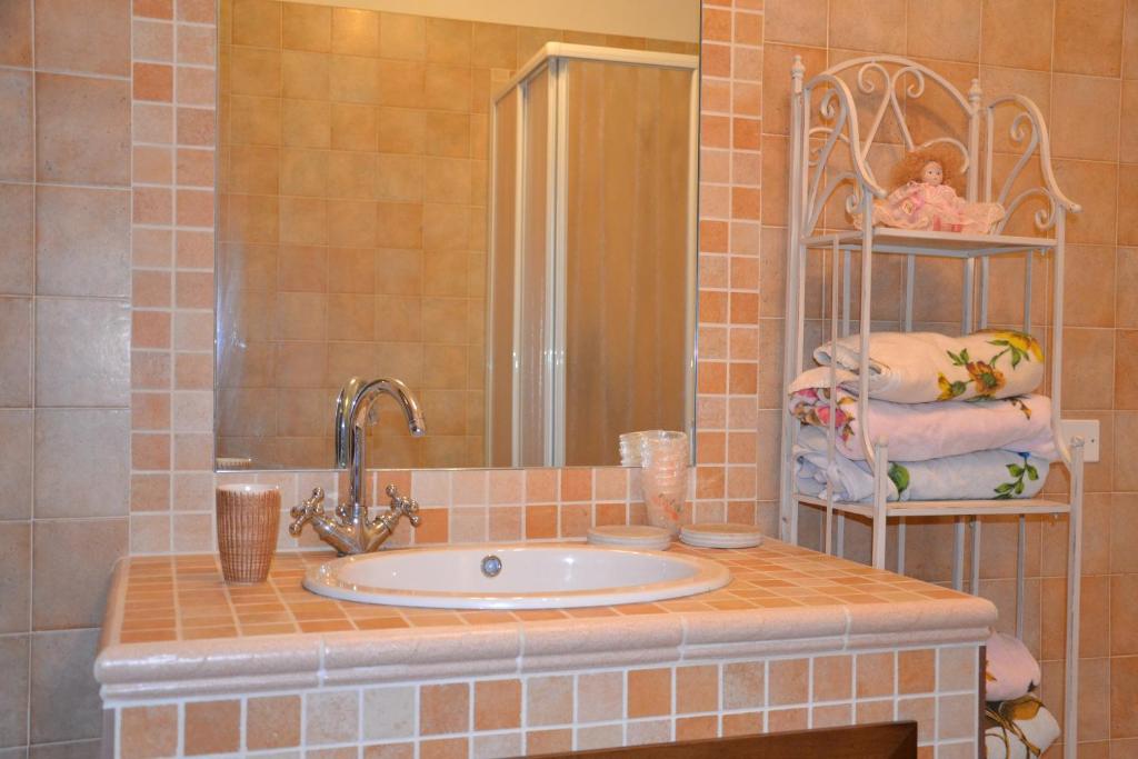 une salle de bain avec un lavabo, un miroir et des serviettes dans l'établissement Casa di Romano, à Terni