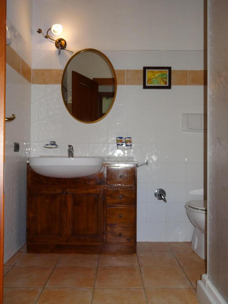 une salle de bain avec un lavabo et un miroir dans l'établissement Villa with private swimming pool and private garden in quiet area, panoramic views, à Radicondoli