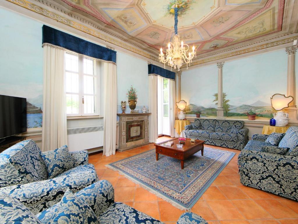 Elle comprend un salon doté d'un mobilier bleu et d'un lustre. dans l'établissement Villa Paolotti by Interhome, à Bettona