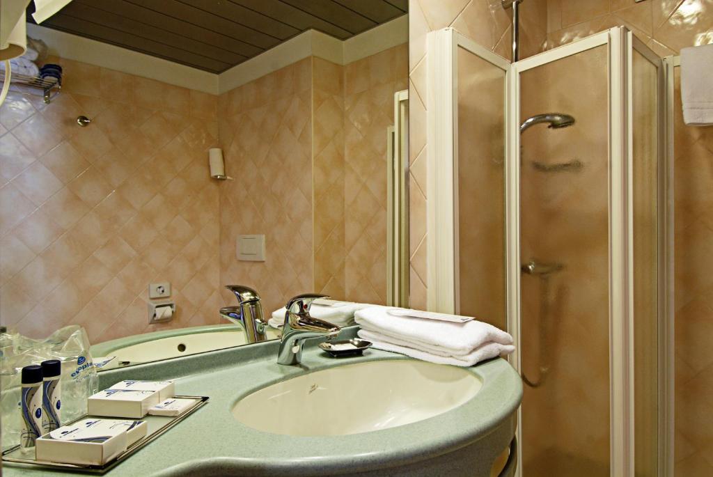 une salle de bain avec un lavabo et une douche dans l'établissement Hotel Sportsman, à Bardolino