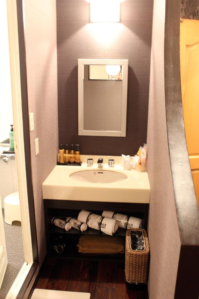 une salle de bain avec un lavabo et un miroir dans l'établissement Hida Takayama Hotel Viera Resort (Adult Only), à Takayama