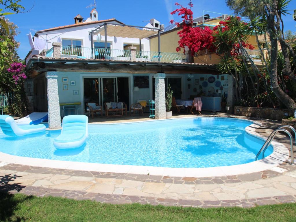 une piscine avec une maison en arrière-plan dans l'établissement Villa Surphinia by Interhome, à Bari Sardo