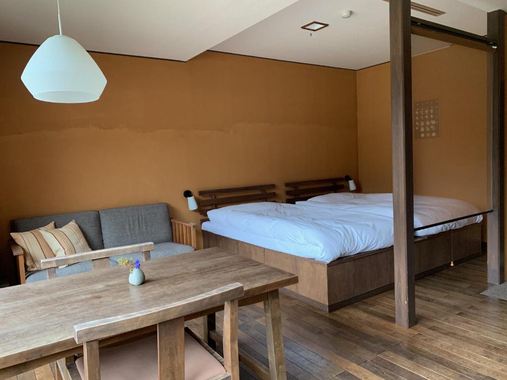 une chambre avec un lit, un canapé et une table dans l'établissement Itamuro Onsen Daikokuya, à Nasushiobara