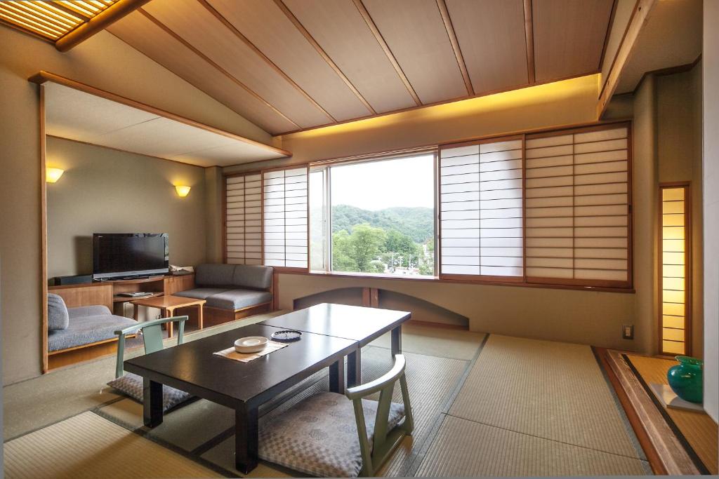 un salon avec une table et un canapé dans l'établissement Hotel New Mitoya, à Sendai